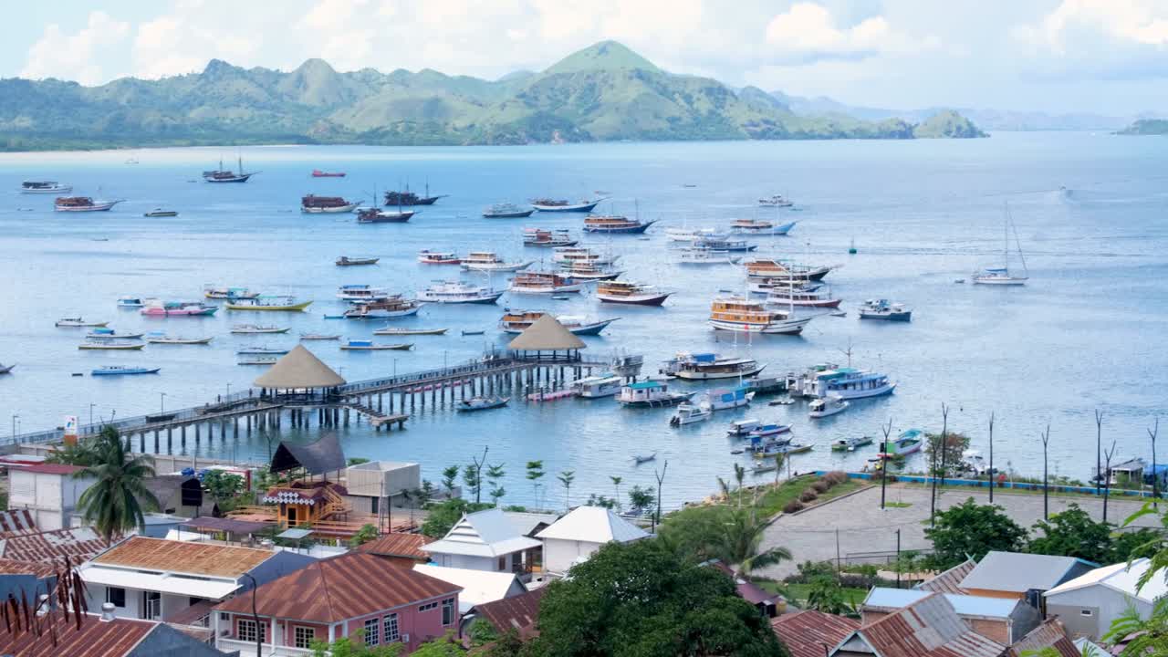 vista panorámica del destino turístico popular de la ciudad de labuan bajo, puerto deportivo, muelle y botes amarrados que esperan recorridos por el parque nacional de komodo en la isla de flores, indonesia
