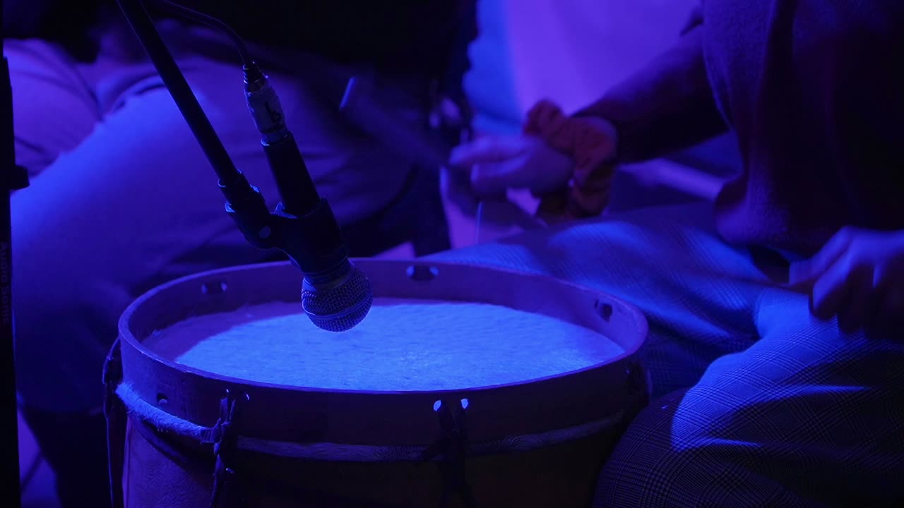 Close-up of a woman's hands playing a chacarera on the "bombo legüero"