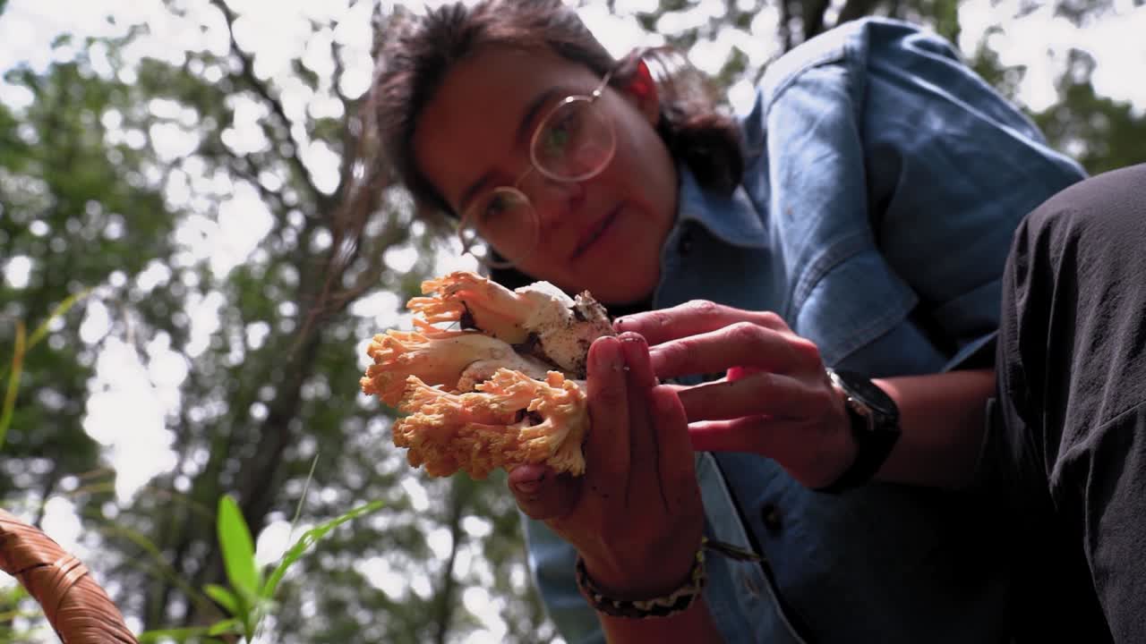 mujer con hongo comestible en las manos en el bosque