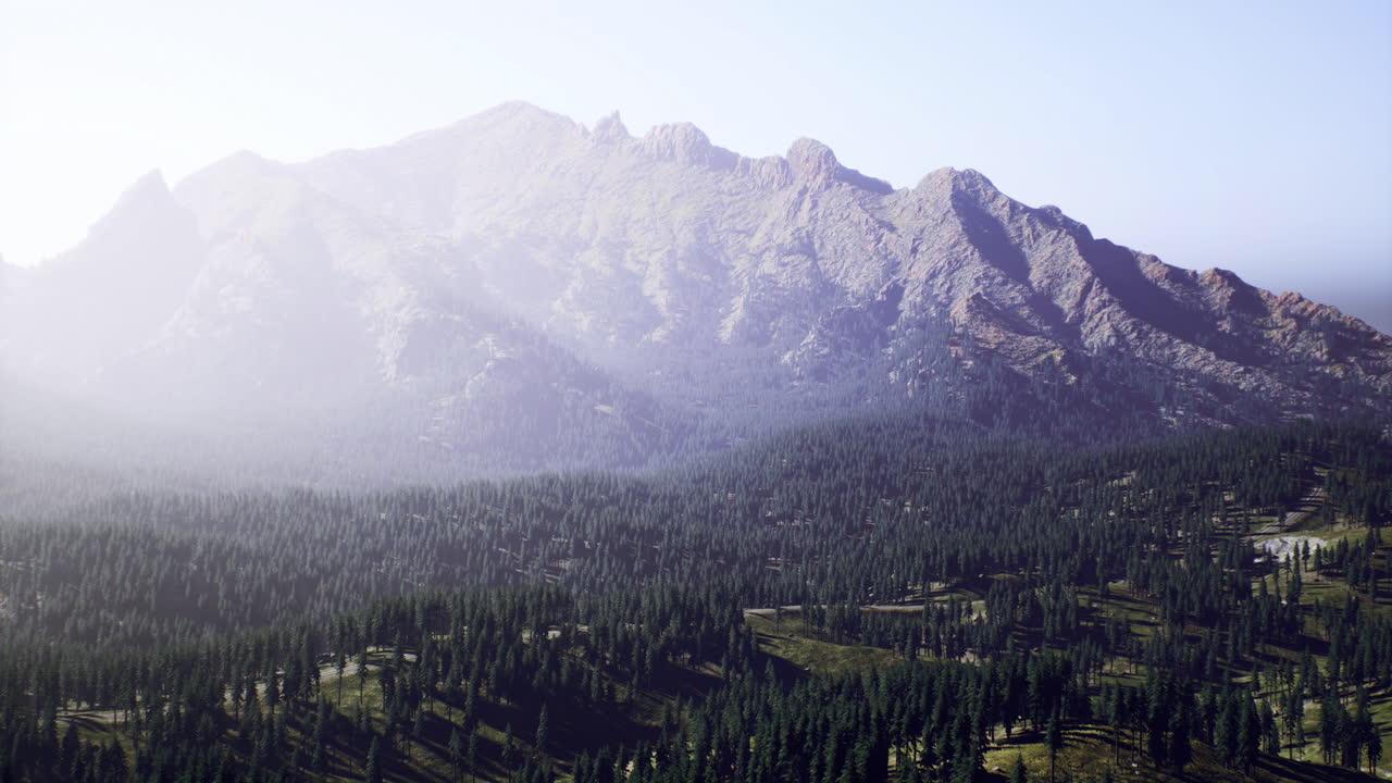 Majestic mountain range covered in trees under soft sunlight