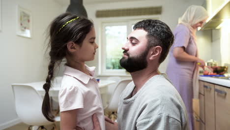 side view of little girl and man in the kitchen.