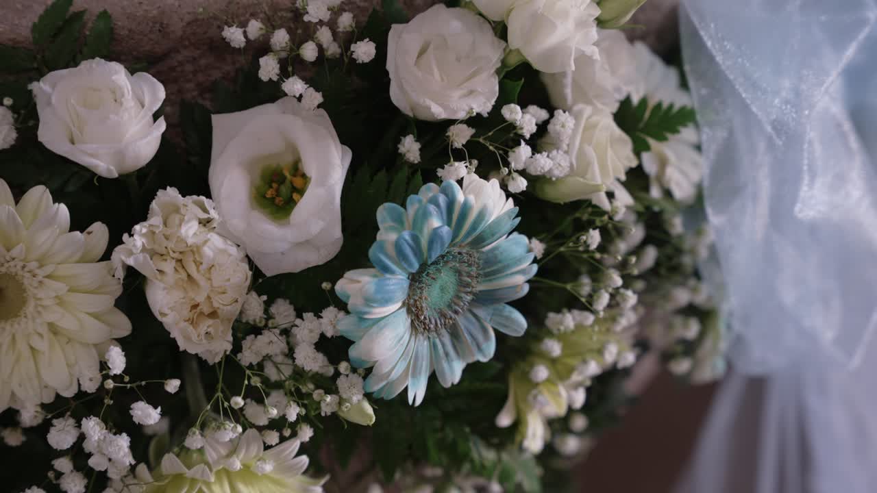 fresh bouquet of blue and white flowers with lace and greenery accents