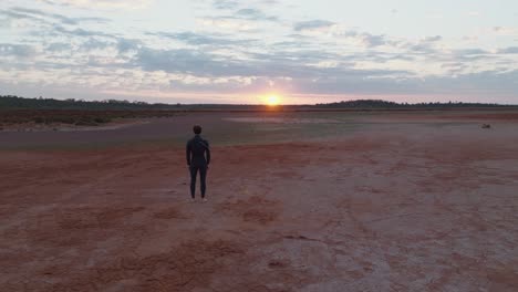 Clip-De-Drones-Avanzando-Pasando-Por-El-Modelo-Masculino-Hacia-Un-Hermoso-Amanecer-Sobre-El-Colorido-Interior-De-Australia