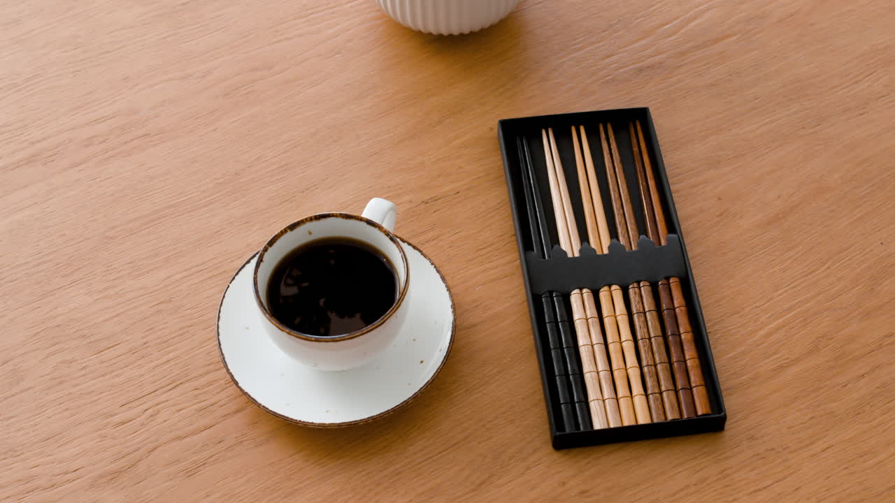 Wooden Chopsticks and Coffee Cup on a Wooden Table
