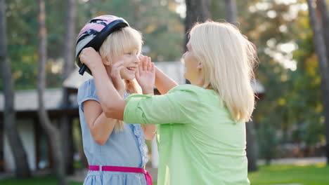 Mom-Puts-On-A-Protective-Helmet-For-Her-Daughter-Concept---Care-And-Safety-4k-Video