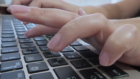 female hands typing on a laptop, composing an email, report, or digital content.