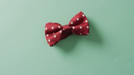 Video-of-red-dotted-bow-tie-lying-on-green-background