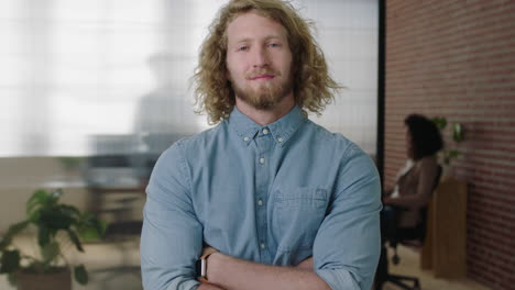 portrait of young charming blonde businessman  entrepreneur looking proud confident at camera arms crossed in contemporary office workspace