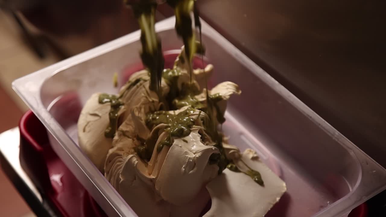 Salsa al pistacchio versata a filo su gelato cremoso.