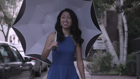 stabilized shot of an asian woman walking down the street with a black and white umbrella