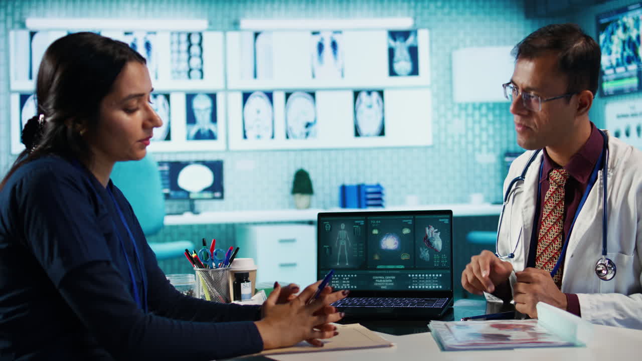 Doctor and Nurse Discussing Medical Data on Laptop