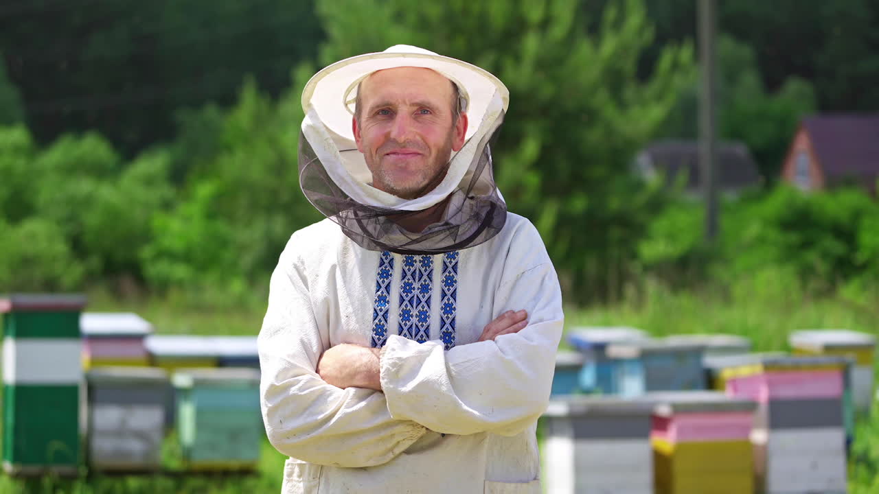 Beekeeper in protective workwear. Portrait of happy male beekeeper at apiary