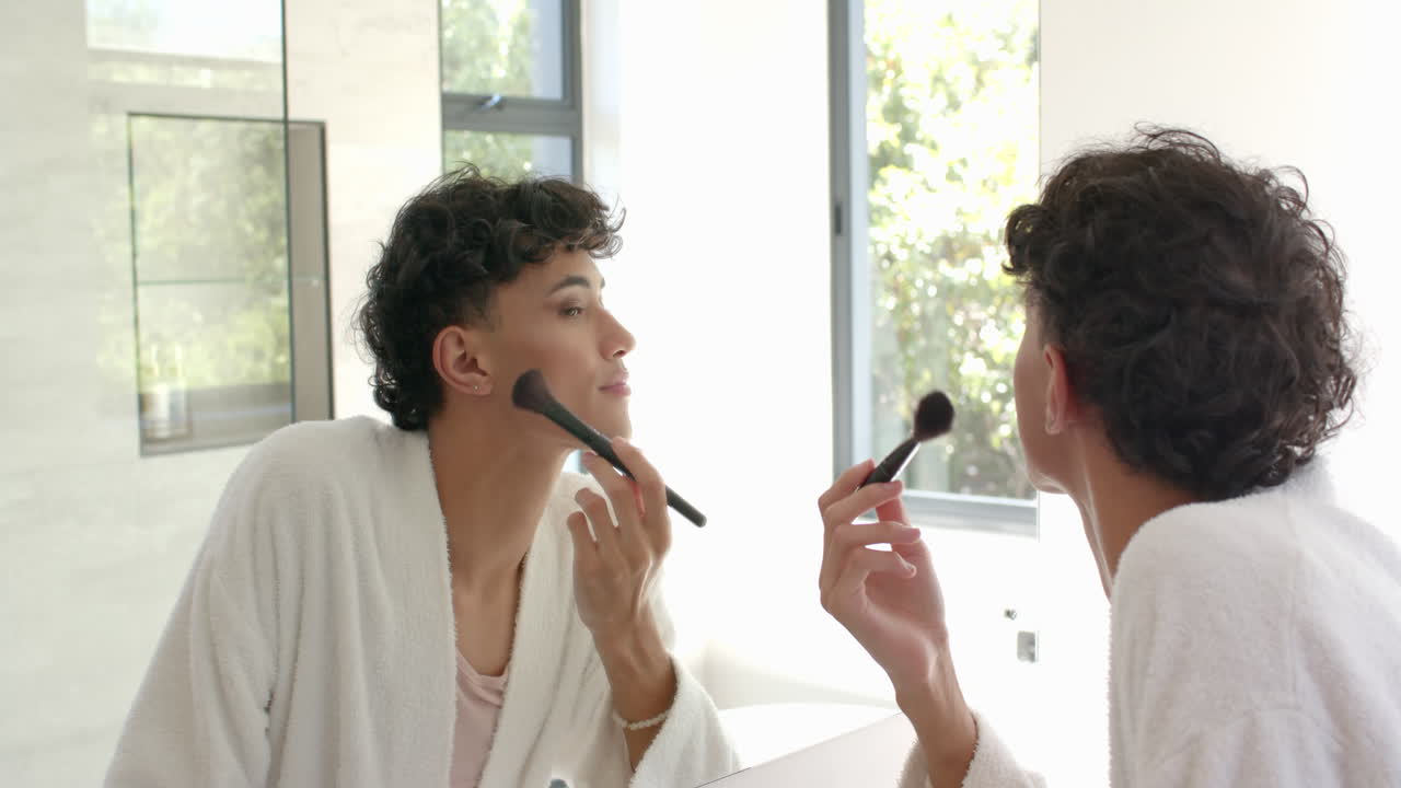 Applying makeup, non binary person using brush and looking in mirror at home