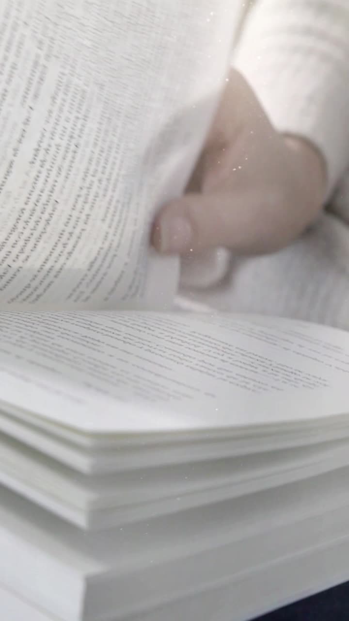 Close-Up of a Hand Turning Pages of a Book While Reading