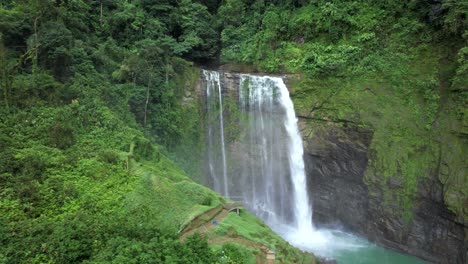 aerial truck right of eco chontales waterfall streaming into turquoise natural pond surrounded by green jungle, costa rica