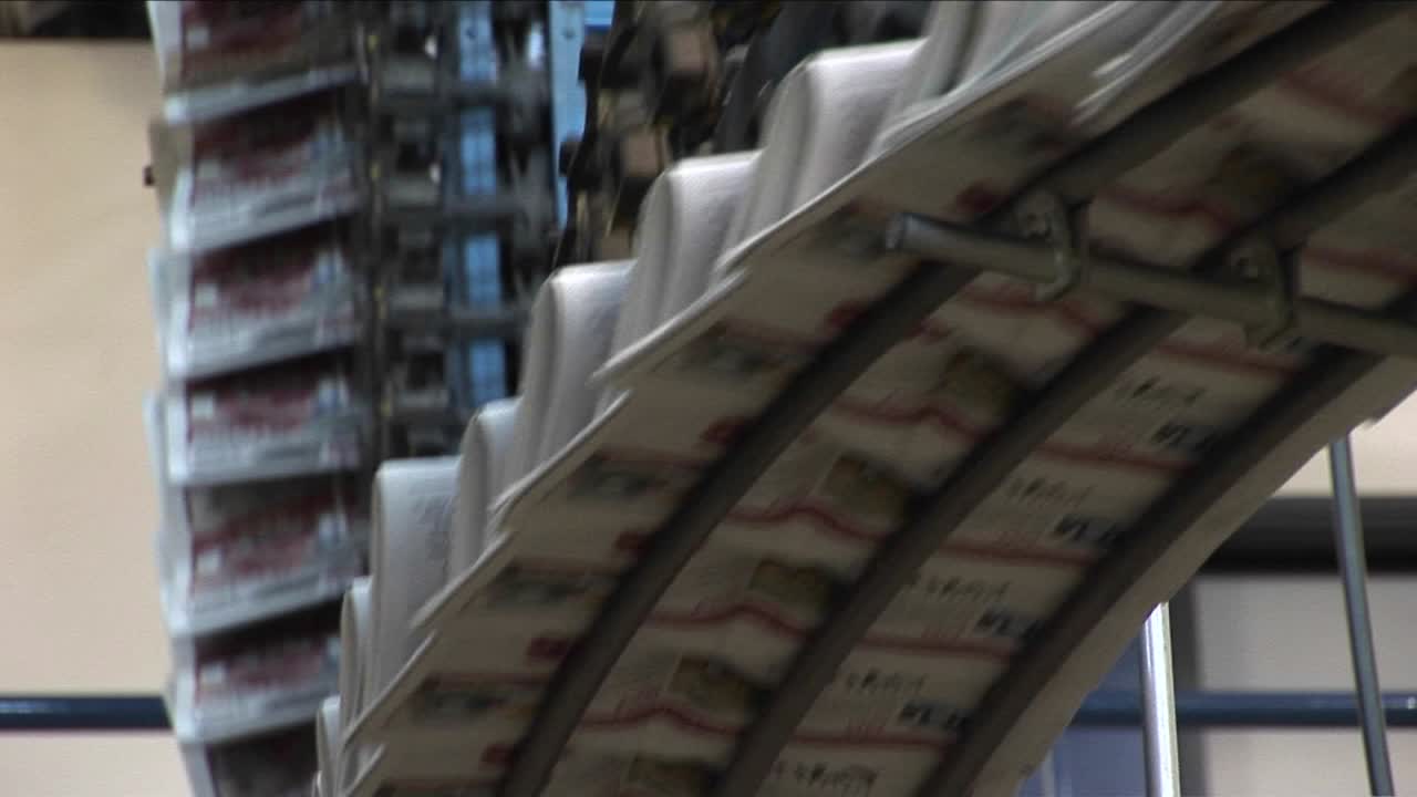 Newspapers move along an assembly line in a factory 4