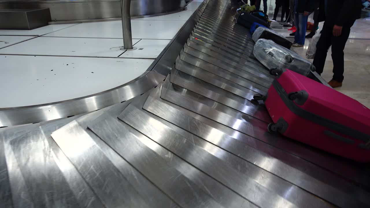 Bagageudlevering i lufthavnen. Passagerer venter på deres bagage efter ankomst