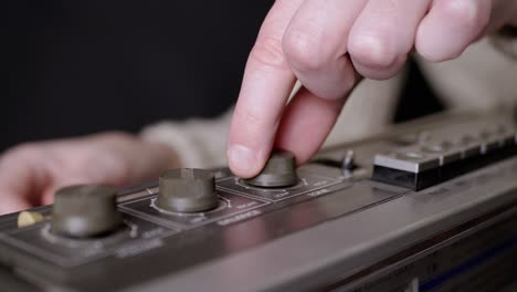 female fingers spinning the volume, balance knobs on an old tape recorder. 4k