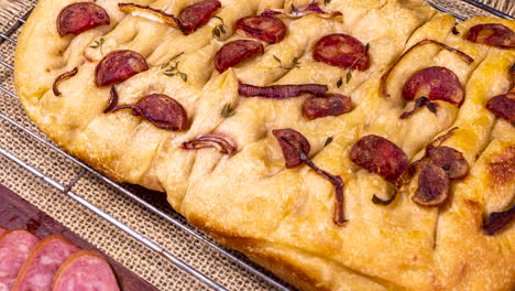 Traditional-Italian-Focaccia-with-pepperoni,-cherry-tomatoes,-black-olives,-rosemary-ando-onion---homemade-flat-bread-focaccia