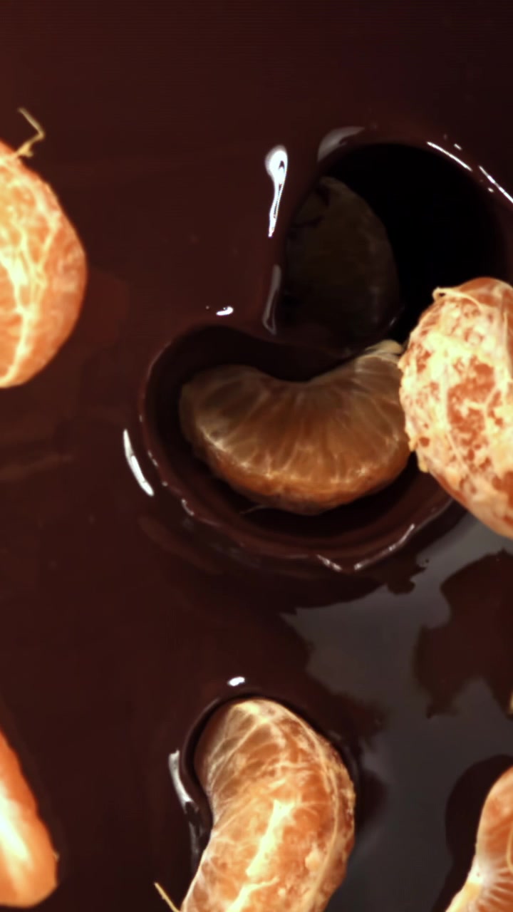 Chocolate derretido vertido sobre gajos de mandarina frescos