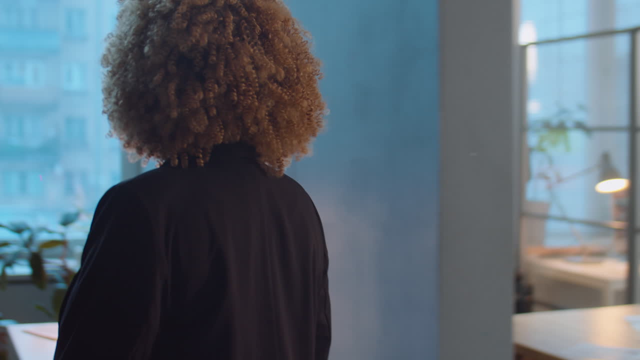 Donna d'affari afroamericana che si dirige verso il posto di lavoro in ufficio