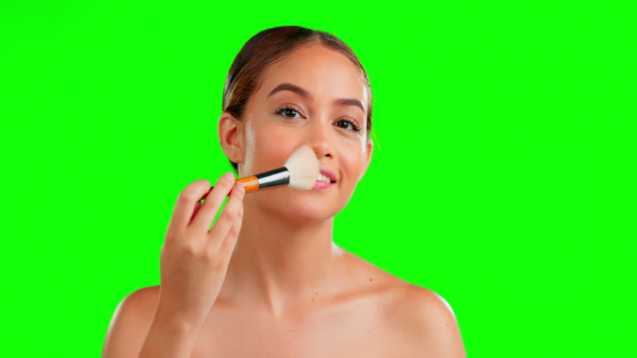 maquillaje, pantalla verde y pincel en la cara de la mujer