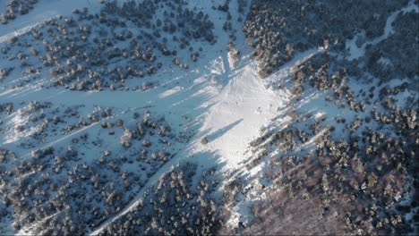 top down aerial view snow covered ski slope empty of people sunset