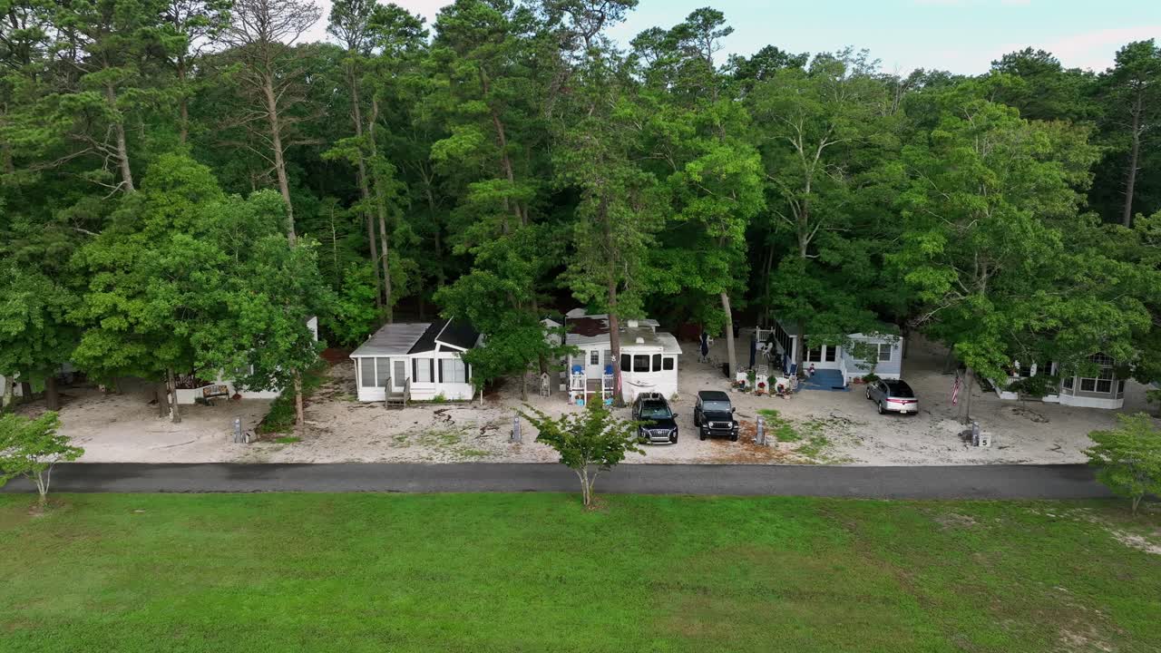 Camping Apartments in wilderness of New Jersey. Parking cars in nature. Aerial shot. Summer day with green trees on campground area. Family trip in USA
