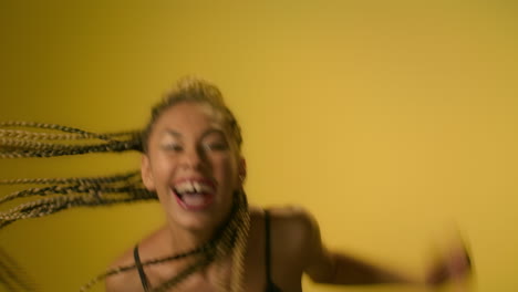 Exited-woman-laughing-and-jumping-for-joy-on-yellow-wall-background-in-studio