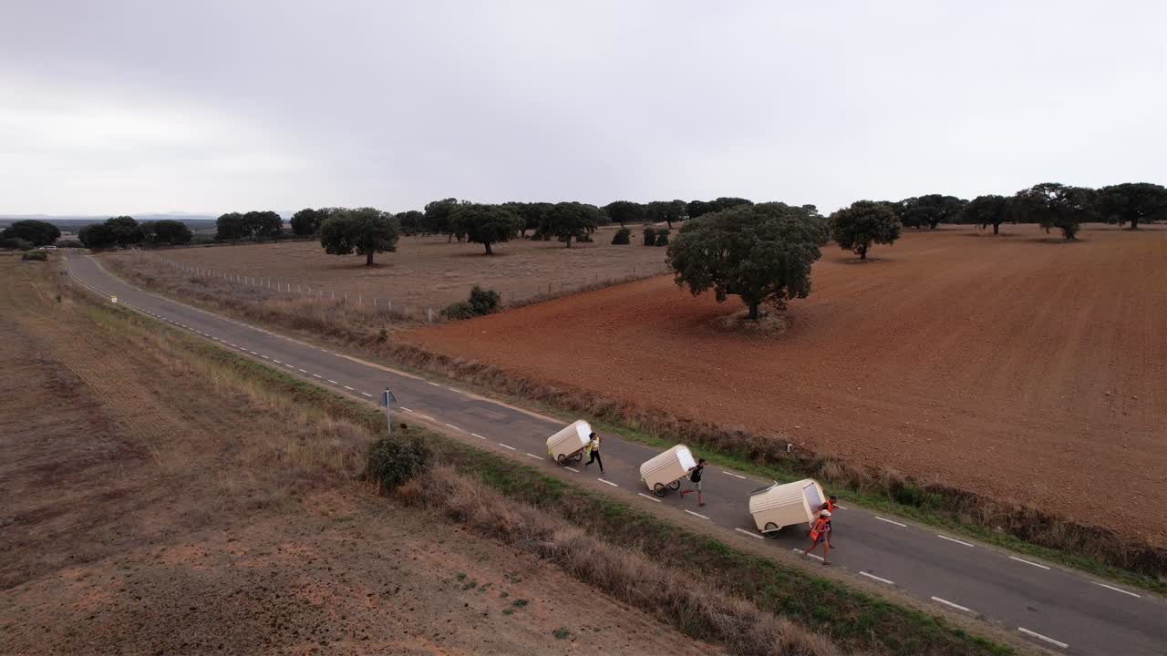 Famiglia nomade che traina piccole case su ruote in campagna in Spagna.