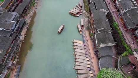 Traditional-boats-docked-along-the-Tuo-Jiang-River-in-Fenghuang-Old-Town,-China