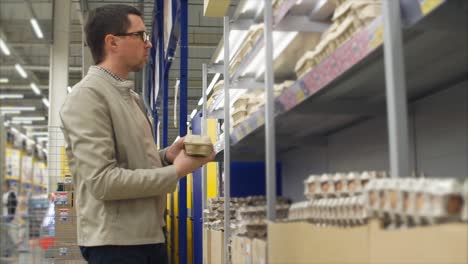 man shopping for eggs in a grocery store