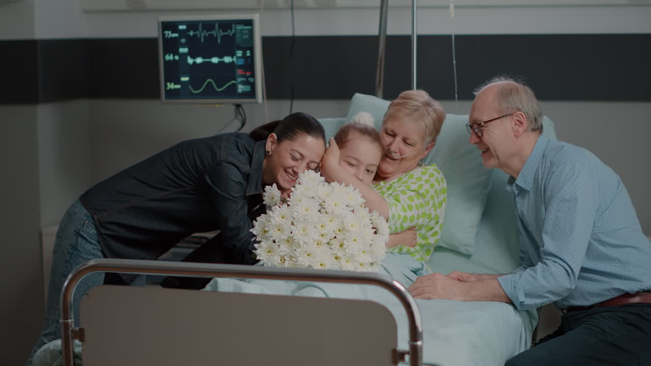 Close up of visitors bringing flowers to sick woman in bed