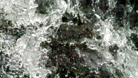 Extreme-closeup-of-crystal-clear-water-hitting-a-rock-shot-in-slow-motion-at-180-frames-per-second