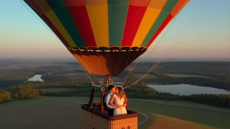 romantic couple embracing in a hot air balloon during sunset or sunrise