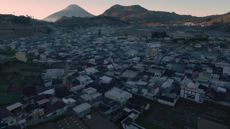 vuelo aéreo sobre una ciudad indonesia entre montañas durante el amanecer por la mañana - meseta de dieng, vecindario indonesio