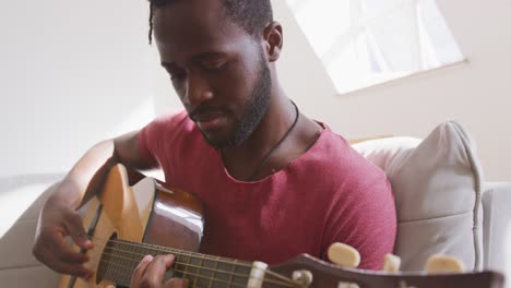 man playing guitar at home