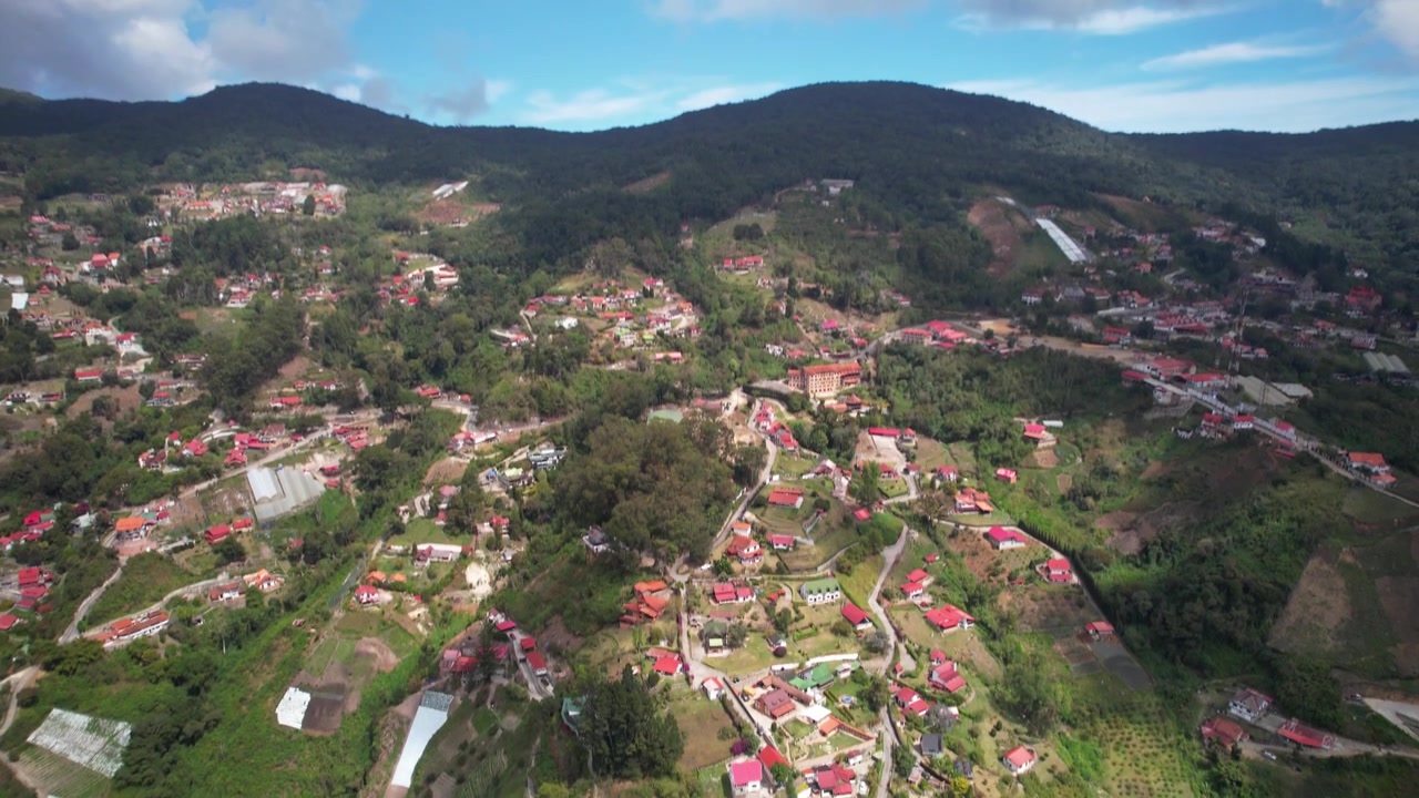 Panoramica verso l'alto di una valle di montagna e campagna, sfondo tranquillo ripreso da drone.