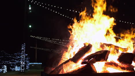 Ziehen-Sie-Den-Clip-Eines-Großen-Lagerfeuers-In-Zeitlupe-Heraus,-Das-Nachts-Hell-Brennt