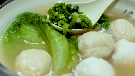 delicious noodle soup with meatballs and greens