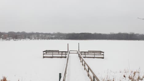 snow covered dock on a frozen lake during winter