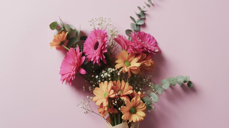 Video di un mazzo di fiori multicolori e spazio per il testo su sfondo rosa