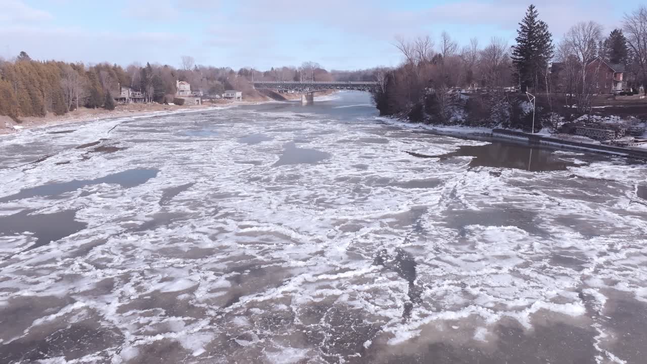 Southampton's icy river with surrounding winter landscape, a bridge in the distance, aerial view