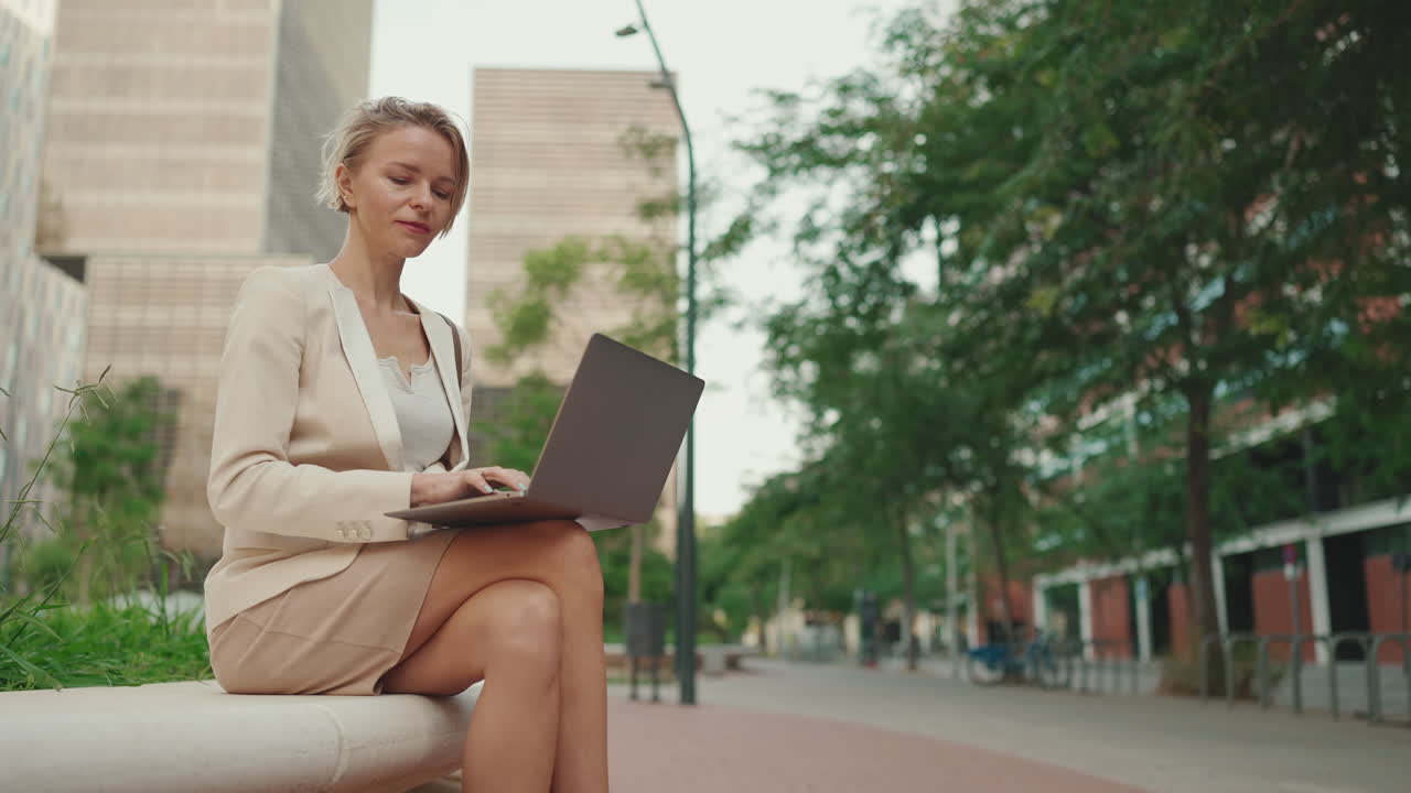 Businesswoman working on laptop in urban environment