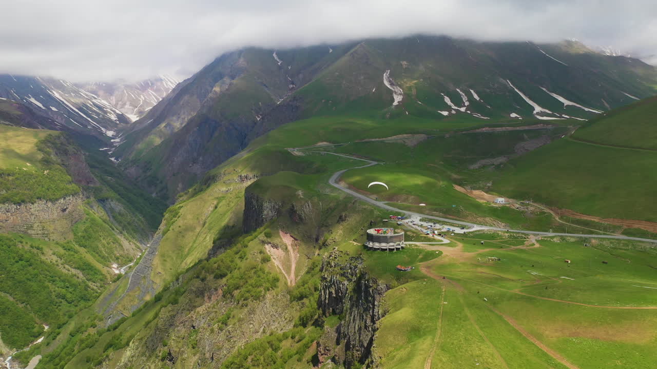 amplia toma de parapente volando cerca del arco de la amistad de los pueblos en gudauri georgia