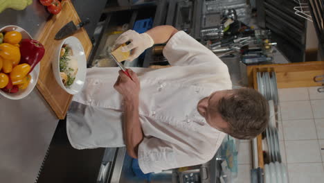 chef grating parmesan cheese on salad