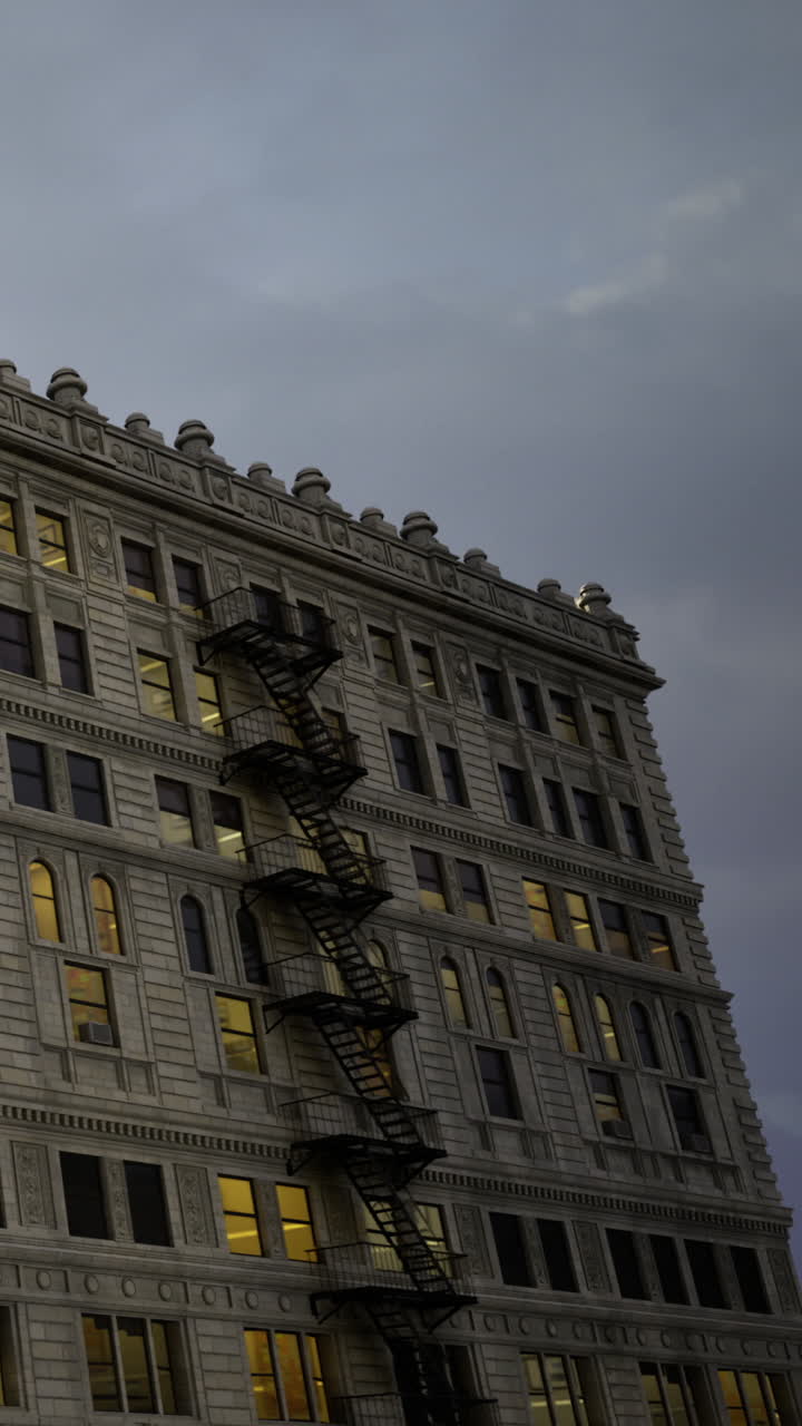 Edificio antiguo con escalera de incendios y ventanas al atardecer en una ciudad