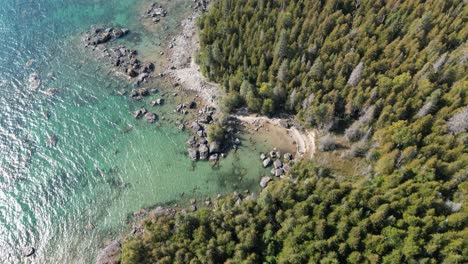 Aerial-pan-to-top-down-view-of-small-rocky-cove-along-lake-huron-coastline,-michigan