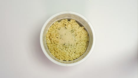 preparing a quick ramen noodles in a white box, plastic cup