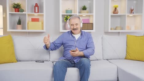 Happy-old-man-at-home-calmly-listening-to-music-on-headphones.